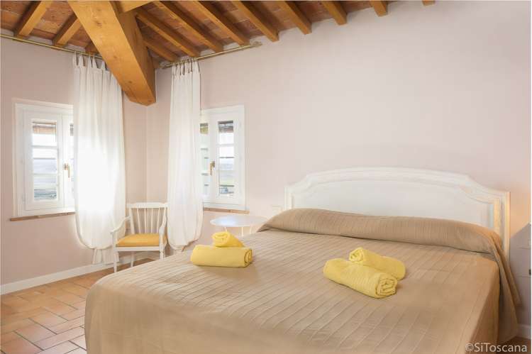 Bildet viser ett av soverommene i ferieleiligheten Torre på vingården Borgo Etruschi i Toscana. Formidlet av SiToscana.
