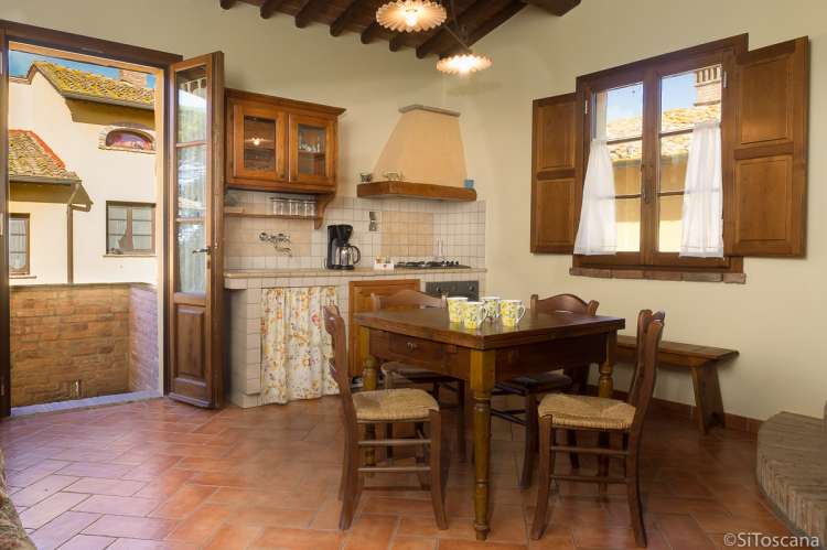 Lucciola med oppholdsrom og kjøkken. Bildet viser oppholdsrom med kjøkken i feriebolig på vingård i Toscana.