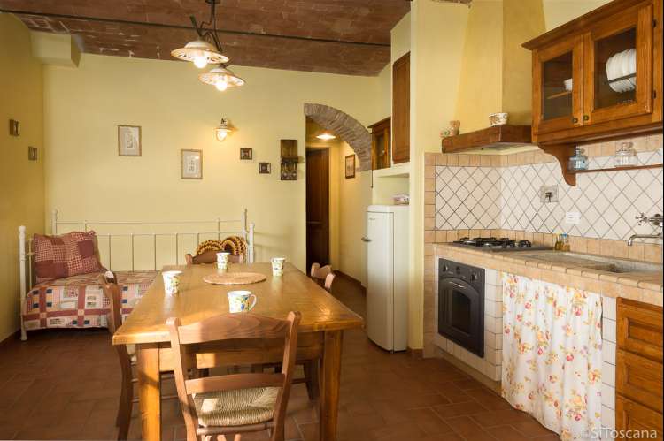 Cavallino har ekstra sengeplass i oppholdsrom/kjøkken. Bildet viser kjøkken med spisebord i feriehus på vingård i Toscana.