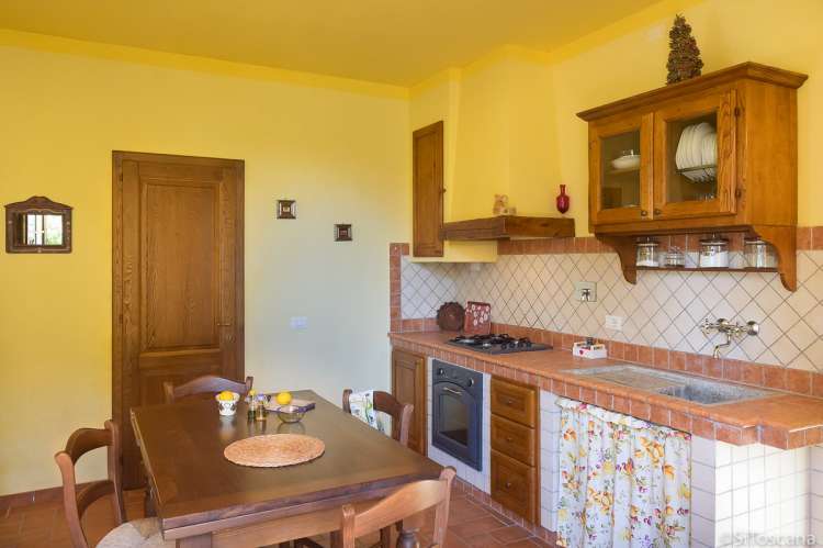 Cecco Bilenco har direkte utgang til egen uteplass fra oppholdsrom/kjøkken. Bildet viser kjøkken med spisebord i feriehus på familievennlig vingård i Toscana.