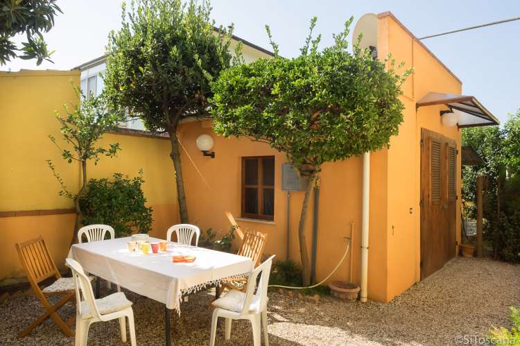 Uteplassen til Vera. I bakgrunnen er bod med husets sykler. Bildet viser uteplass med sitrontrær ved feriehus sør for Pisa i Italia.