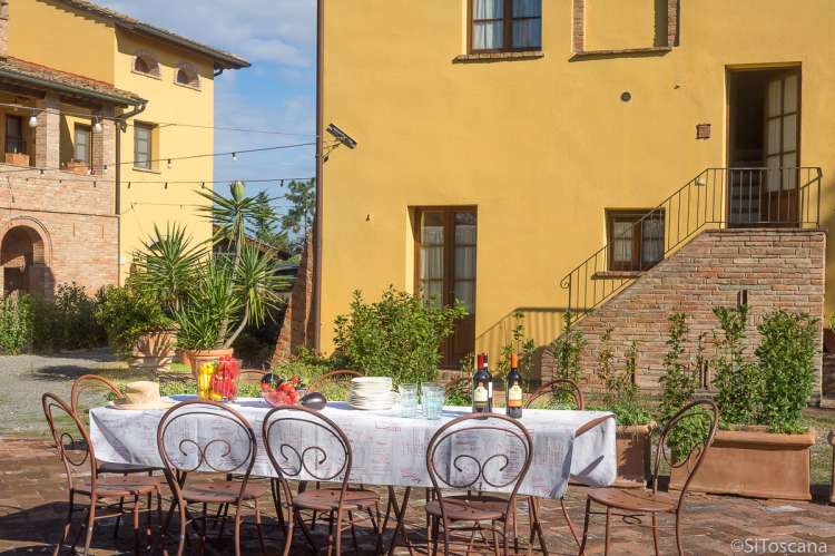 Trapp opp til Domani è Festa i bakgrunnen. Langbord kan ordnes på felles uteplass når dere er mange sammen. Bildet viser langbord på barnevennlig vingård med ferieboliger, midt mellom Pisa og Firenze.