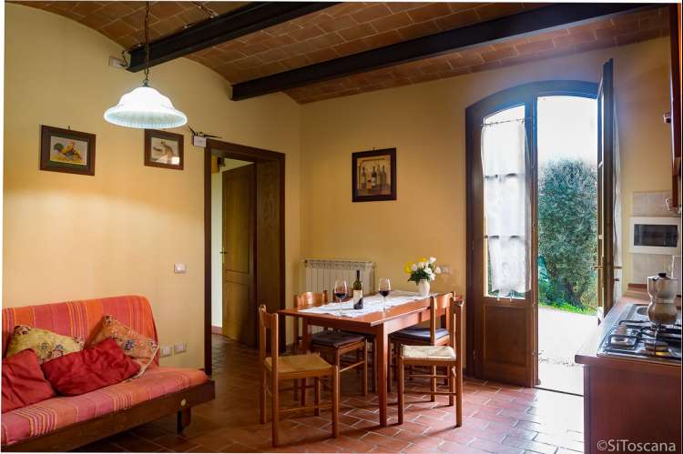 Bildet viser stue og spisebord i feriebolig på vingård med vinsmaking i Toscana.