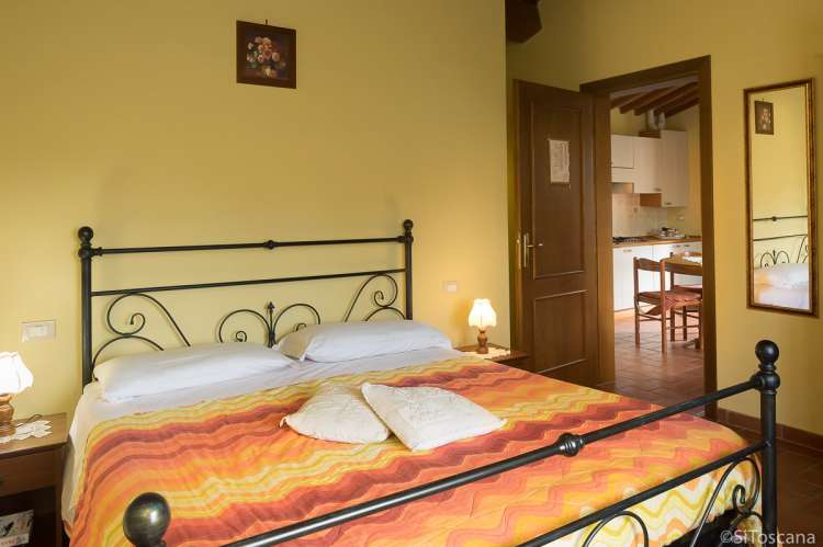 Bildet viser soverom med dobbeltseng i feriehus på vingård med utsikt nært Pisa..