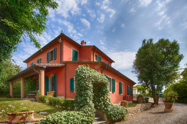 Bildet viser feriehus på olivengård ved landsby i Toscana.