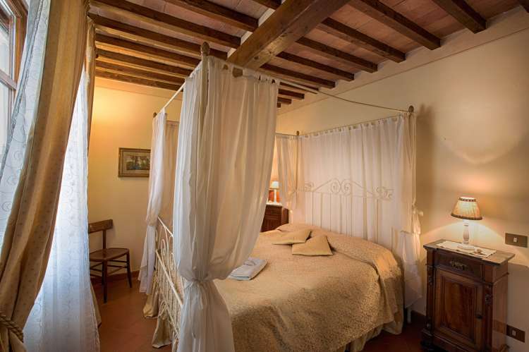 Bildet viser himmelseng i ferieleilighet på olivengård i Toscana.