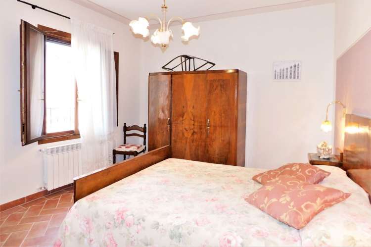 Bildet viser soverom med en dobbeltseng i ferieleilighet på vingård nært Pisa i Italia.