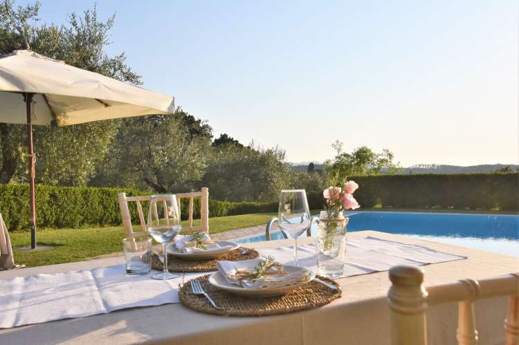 Bildet viser middagsservering ved bassenget på gård med feriehus nært Pisa.