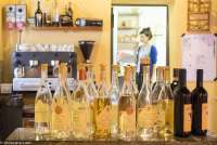 Bildet viser utvalget av grappa og Vin Santo på spisestedet Trattoria di Montemagno, like utenfor Pisa. I bakgrunnen skimtes en av servitørene.