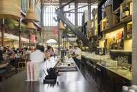 Bildet viser servitør som tapper øl og kunder ved en bar i Matmarkedet i Firenze – Mercato Centrale