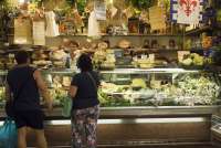 Bildet viser folk som kjøper ost i en ostedisk i Matmarkedet i Firenze – Mercato Centrale