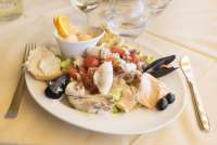 Bildet viser en tallerken med sjømat på en restaurant i Tirrenia i Toscana. På fatet ser du blåskjell, blekksprut, fisk, salat, tomat, løk og oliven.,