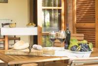 Bildet viser oppdekt lunsjbord med brød og vin. Bordet står ute på en terasse.