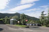 Bildet viser en del av den offentlige parkeringen nederst i landsbyen Montemagno. Her er det merkede hvite felt og gratis parkering. Her er også bussholdeplass for bussen til Calci og Pisa samt en oppslagstavle.