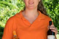 Bildet viser ung kvinnelig vinbonde som viser fram to vinflasker.