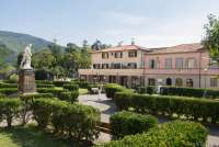 Bildet viser en kvinne som fotograferer statuen som står i parken utenfor kommunehuset i landsbyen Calci., Pisa, Toscana, Italia.
