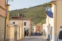 Bildet viser hovedgata Via Roma i Calci. Du ser skiltet til en papirhandel og en bar.