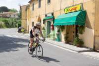 Bildet viser mann som sykler på  landeveissykkel i landsbyen Fauglia i Toscana.