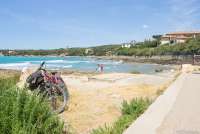 Bildet viser sykkel parkert ved strandpromenaden i Castiglioncello. I bakgrunnen skimtes et par som tørker seg etter å ha bedet i sjøen.
