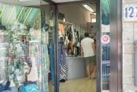 Bildet viser utstillingsvinduet og litt innenfra en av butikkene for dameklær i Tirrenia. En mannlig kunde står ved disken og prater med ekspeditøren.