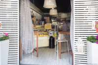 Bildet viser inngangspartiet og disken i en av barene i Tirrenia i Toscana. Inne skimter du ekspeditøren og en av kundene.