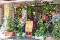 Bildet viser folk som står og sitter utenfor en av de mange kaffebarene i Tirrenia.