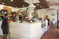 Bildet viser interiøret og servitør og kunde i restauranten og baren Le Gemelle i Calci.