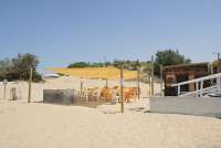 Bildet viser et av spisestedene på stranda Spiaggia Verruca i Tirrenia. Det er uteservering med et solseil over. 