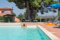 Bildet viser basseng med pinjetre på residensen Vicino Mare sør i Toscana.