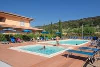 Bildet viser barnebasseng og stort basseng for voksne på residensen Vicino Mare ved sjøen i Toscana.