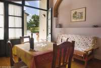 Bildet viser oppholdsrommet med spisebord og sofa samt inngangsdør i leiligheten Geranio på feriebostedet Girasole, vingård med 10 leiligheter og gangavstand til landsby.