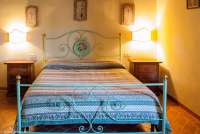 Bildet viser soverom med dobbeltseng i leiligheten Edera på feriebostedet Girasole, vingård med 10 leiligheter og gangavstand til landsby.