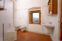 Bildet viser ett av badene i Villa Pace.  Vindu med utsikt mot Pisa