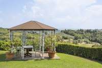 Flott utsikt mot vinmarker, olivenlunder og åsene rundt gården. Lysthus med utsikt mot vinmarker og olivenlunder på vingården Podere Cenni utenfor San Miniato. Foto.