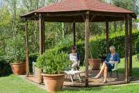 Vingården egner seg godt for store og små. To kvinner som slapper av i skyggen i lysthuset på vingården Podere Cenni utenfor San Miniato. Foto.