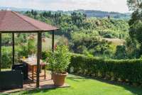 Lysthus med utsikt ved bassenget. Lysthus med utsikt over vinmarkene på vingården Podere Cenni utenfor middelalderbyen San Miniato. Foto.