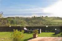 En dag i november på Podere Cenni. Kvinne som slapper av i hagestol og nyter utsikten på vingården Podere Cenni utenfor San Miniato. Foto.