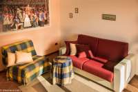 Oppholdsrom med sovesofa i en av suitene. Oppholdsrom med sofa og lenestol i suite på vingården Podere Cenni ved San Miniato. Foto.