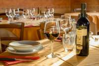 Spisestedet på gården serverer toskansk, hjemmelaget mat og husets viner. Bord pådekt til middag med egenprodusert vin på vingården Podere Cenni utenfor San Miniato. Foto.