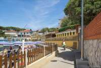 Bildet viser dame på sykkel på strandpromenaden i feriebyen Castiglioncello i Toscana.