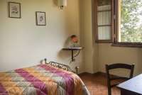 Lucciola har tre soverom. Bilde fra et av soverommene i ferieleiligheten Lucciola. Vindu mot landskapet i Toscana.