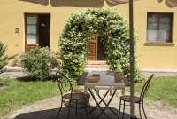 La Bella Lavanderina har rommelig uteplass. Foto av uteplassen til ferieleilighet på vingård i Toscana. La Bella Lavanderina med portal av blomster i hagen.