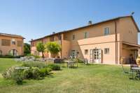 Foto av hovedbygningen med restaurant på vingården Aldobrando. Grøntarealer med boltreplass for barn.