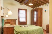 Bildet viser soverom med dobbeltseng i feriehuset Villa Noce i Toscana.