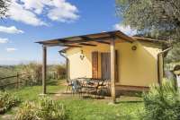 Bildet viser uteplass til Villa Noce, gressplen og blå himmel.