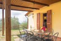 Bildet viser terrassen og inngangen til feriehuset Villa Noce med privat basseng i Toscana.