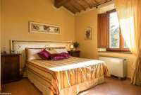 Bildet viser dobbeltseng i ferieleiligheten Ciliegia. På feriebostedet La Pergola ved middelalderlandsby i Toscana.