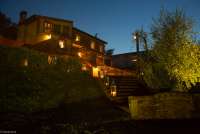 Bildet viser feriebostedet La Pergola om kvelden. Det er mørkt men mange lamper er tent og skaper et varmt og gyldent lys. Ved Pisa i Toscana. 