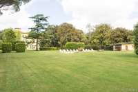 Bildet viser gressplener utenfor stor villa ved Pisa i Italia.