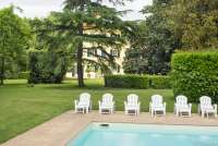 Bildet viser basseng og solstoler utenfor villa til utleie ved Pisa i Italia.